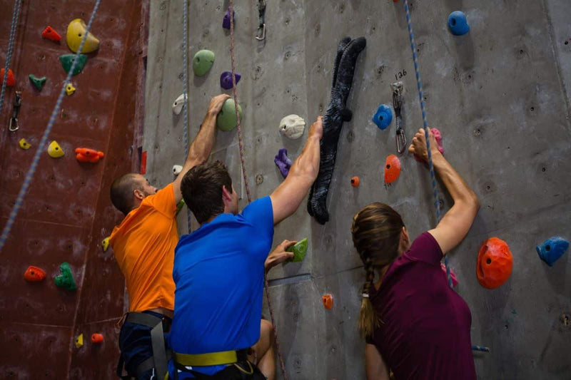 A Man Is Climbing On A Wall With The Help Of Indoor Climbing Rope